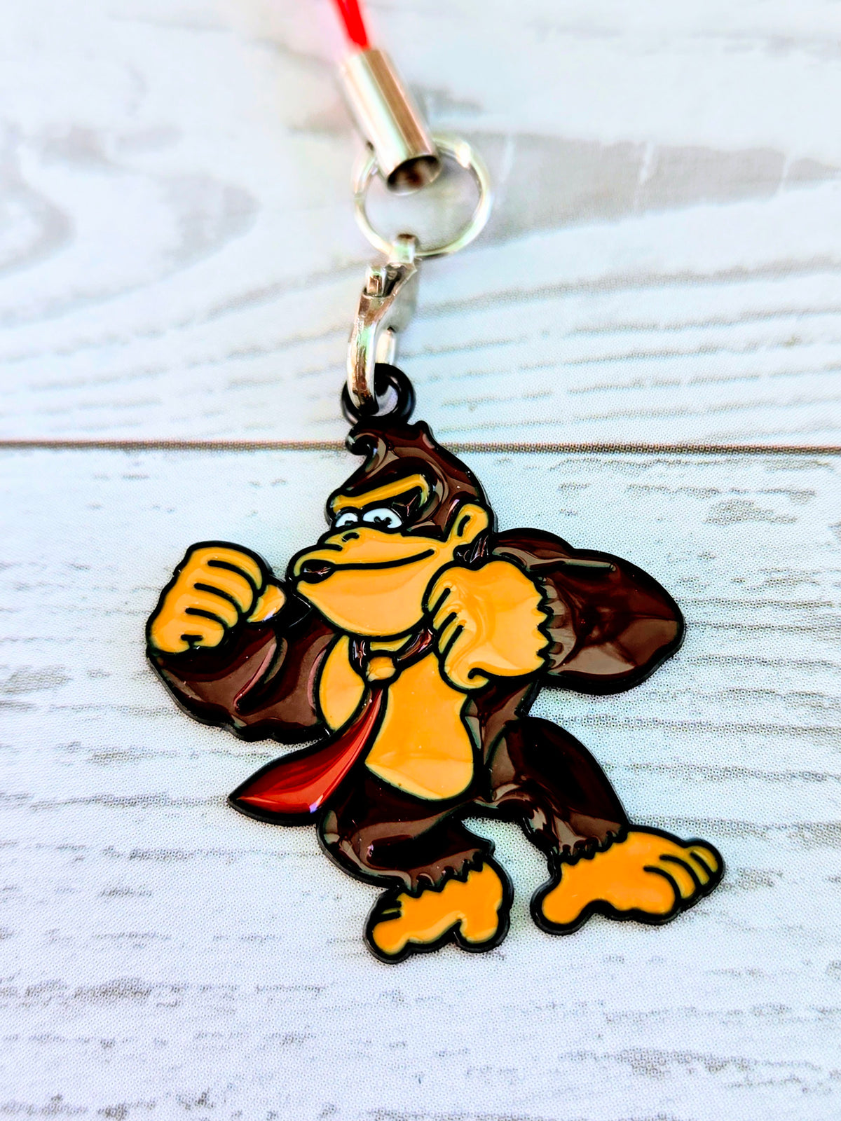 Red cord phone charm wrist strap with Donkey Kong enamel character charm