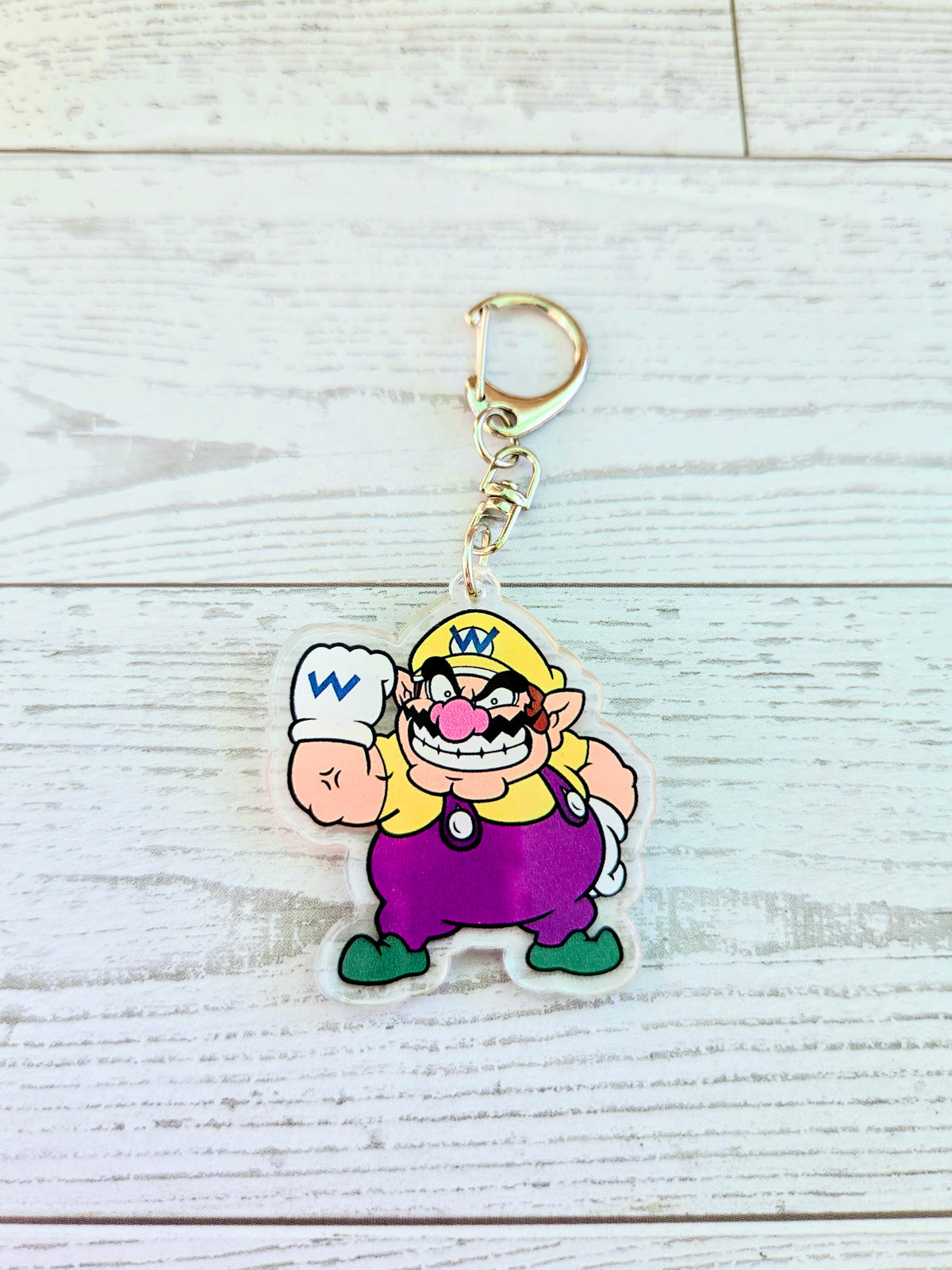 Acrylic keychain featuring Wario holding fist and wearing purple overalls