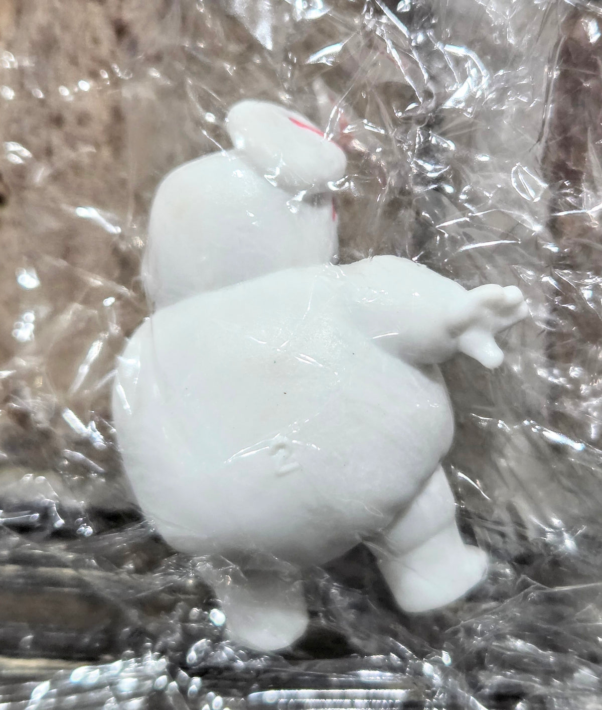 White mini Puft figure with open arms, wearing a red-and-blue striped top.
