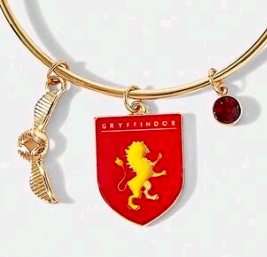 Gold-tone charm bangle bracelet with red Gryffindor shield and round red stone