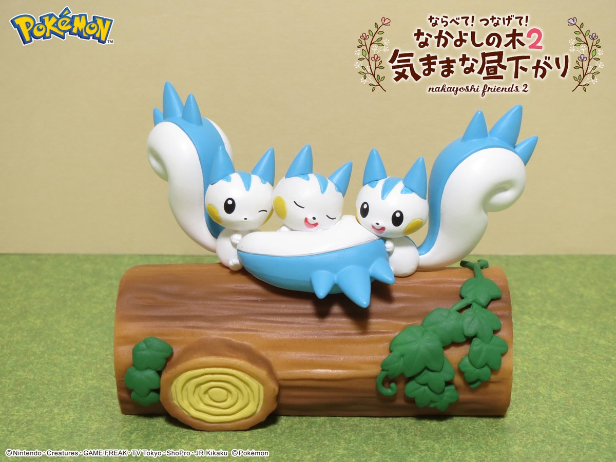 Blue bird toy figures curled together on a brown log with green vine details.