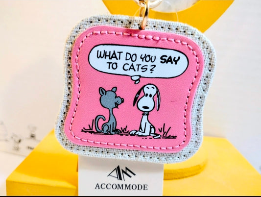 Pink Snoopy keychain patch with text "What do you say to cats?" and keyring