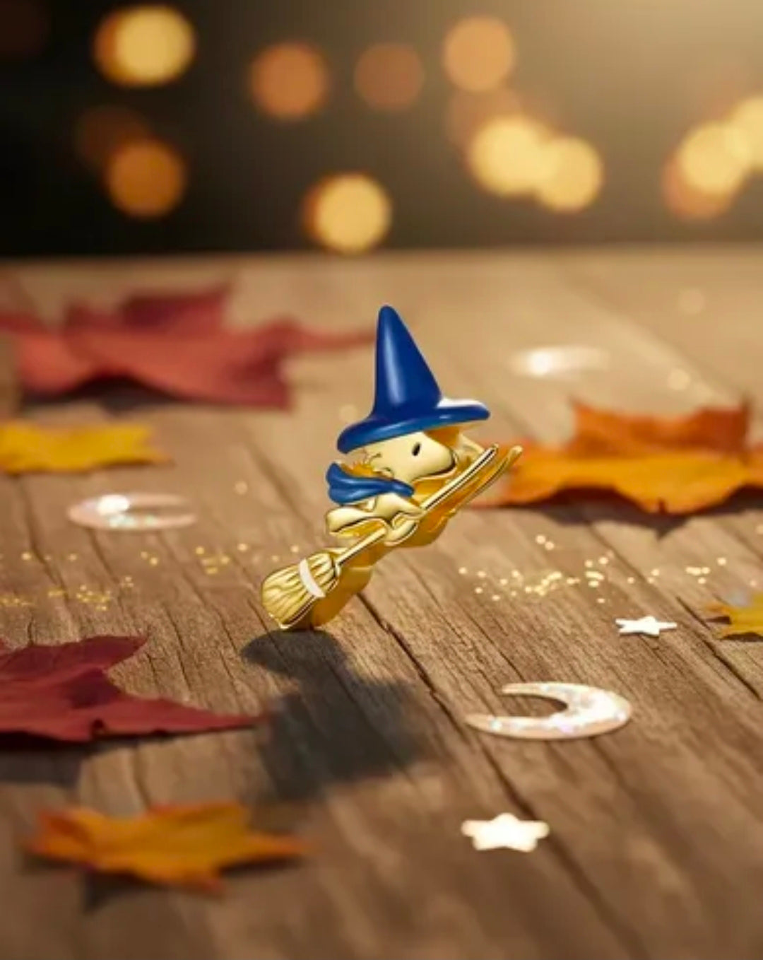 Gold-tone witch charm with blue pointed hat and broom, small pendant figure