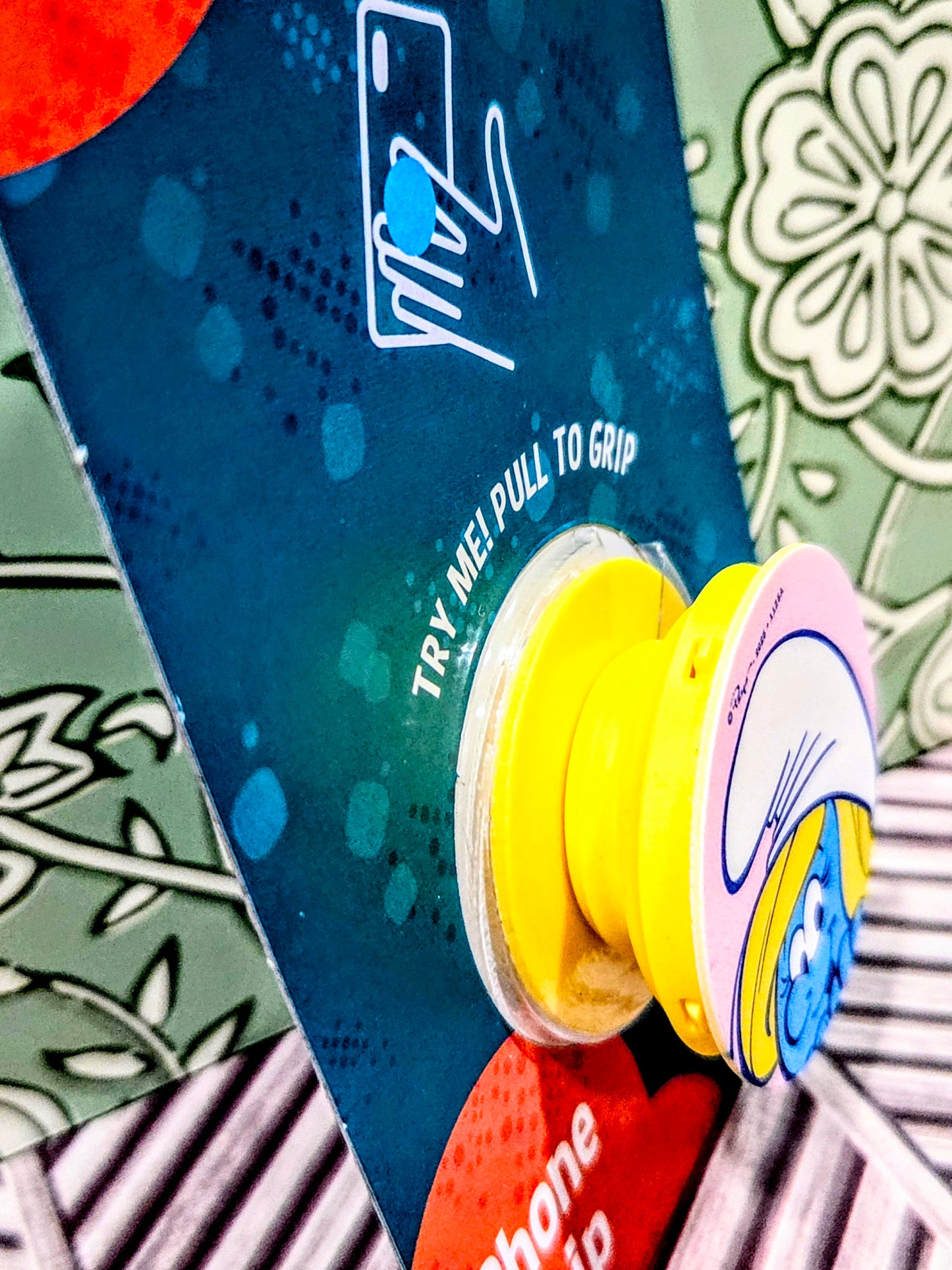 Smurf phone grip holder showing yellow suction-style grip and phone grip label