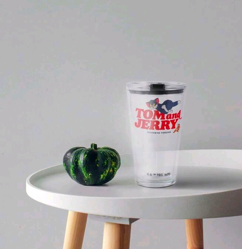 Clear plastic tumbler with black lid and Tom and Jerry graphic on side
