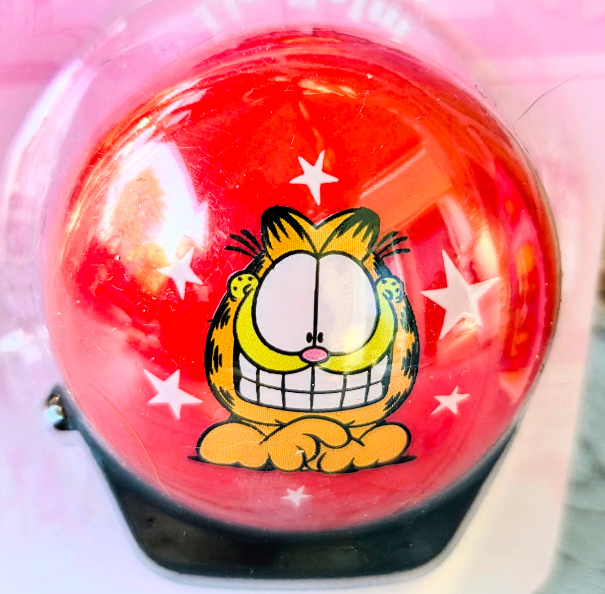 Garfield lip balm in a red dome container with star accents and character face