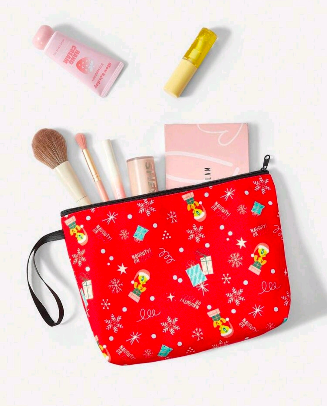 Red Christmas makeup bag with zipper and strap, shown with cosmetics and brushes nearby