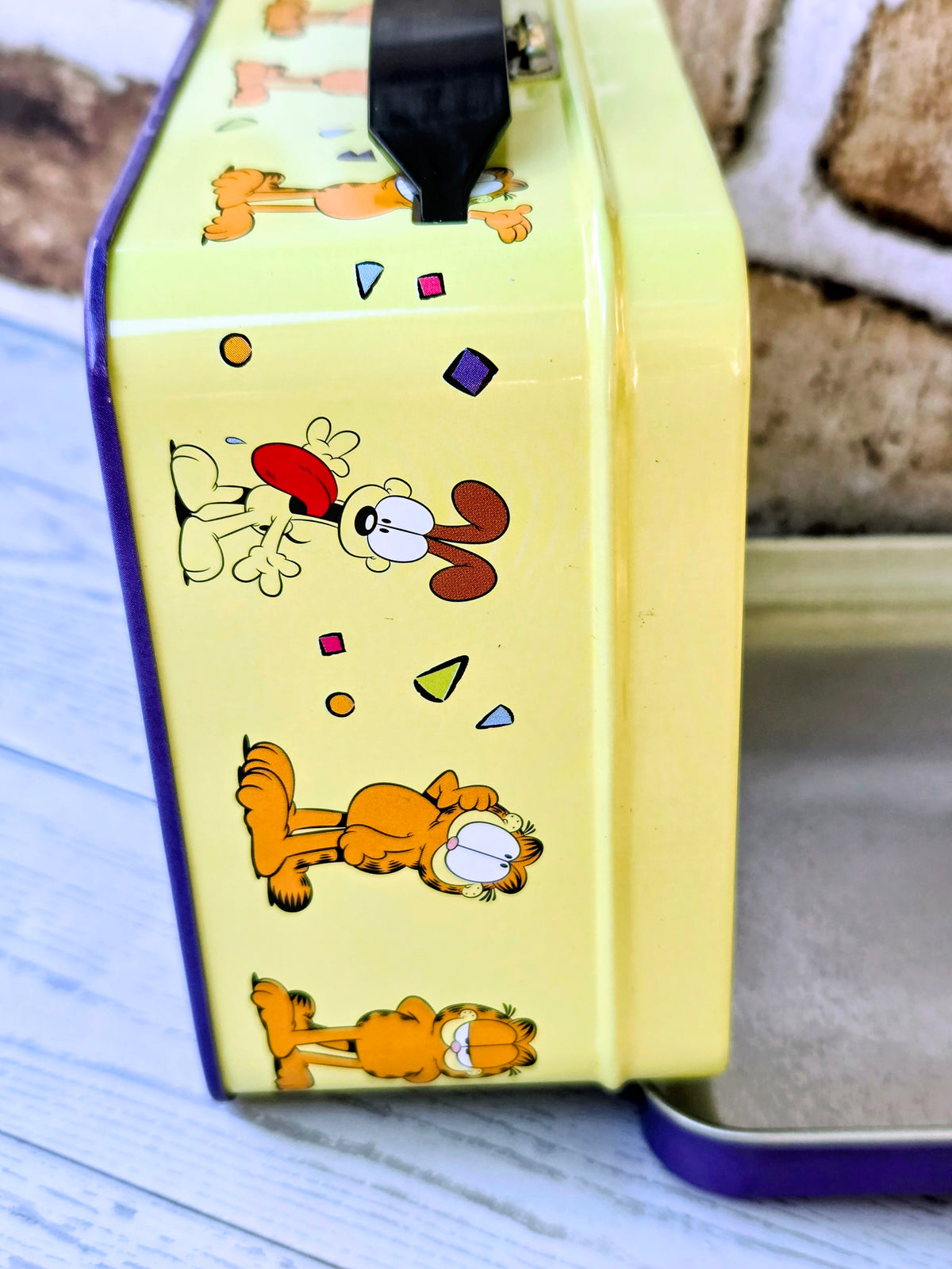 Yellow Garfield pet tin with colorful cartoon graphics and dark purple trim.