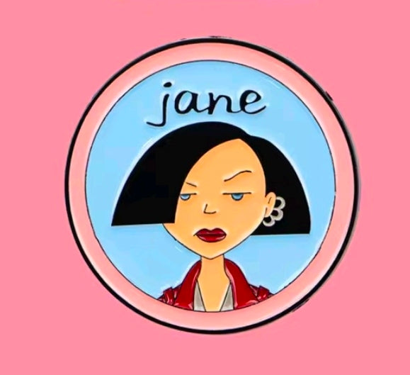 Jane character circle enamel pin with pink rim and light-blue background