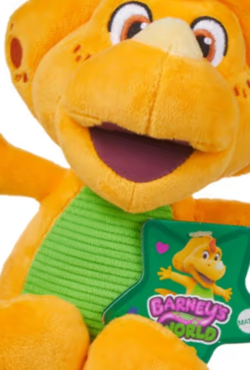 Orange plush dinosaur character with green striped shirt and smiling open mouth, tag on side