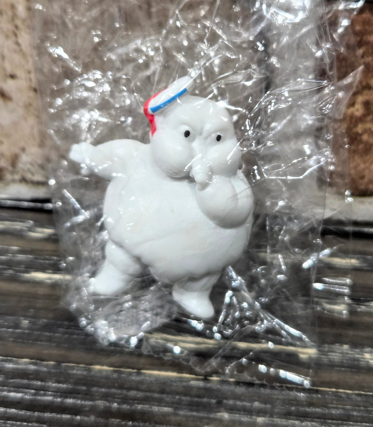 White mini Puft figure sitting on its feet, red-and-blue striped hat detail visible.