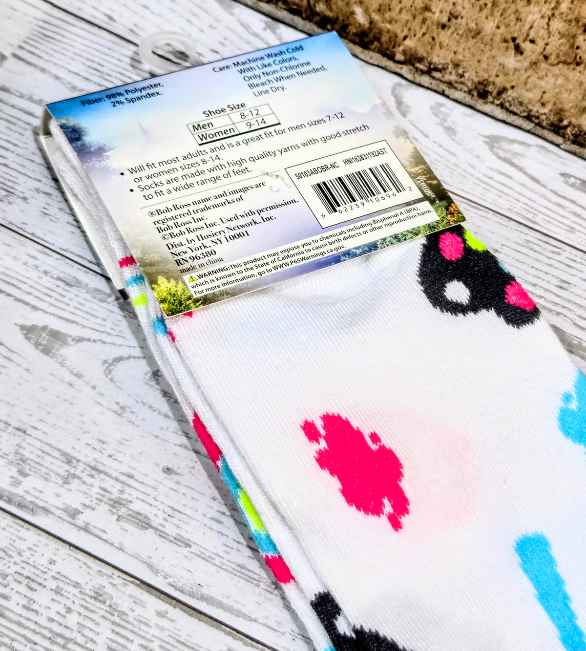 White crew sock with colorful paw-print accents and small red/blue lettering