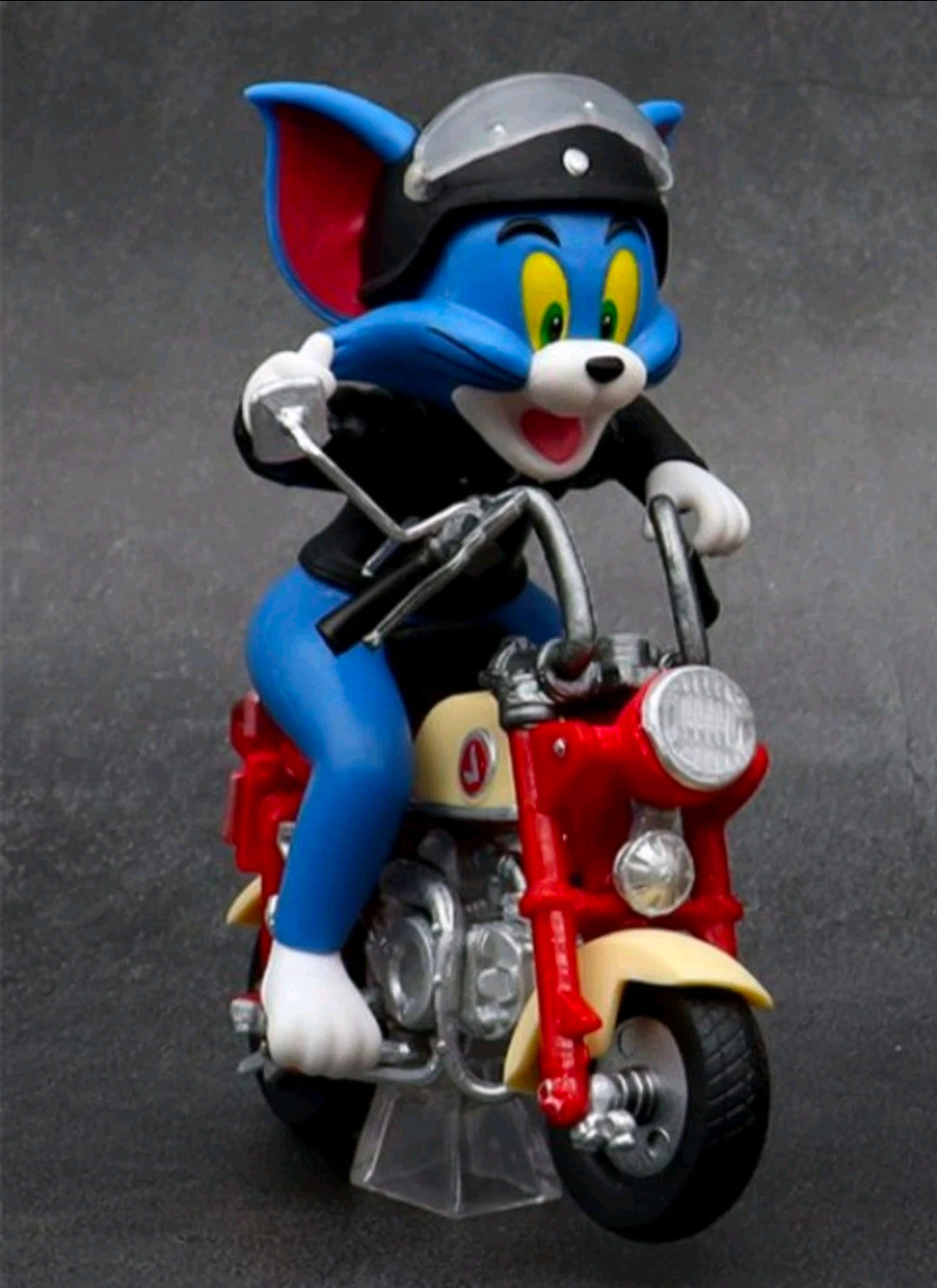 Biker Tom collectible figure on red motorcycle with black jacket and silver engine parts