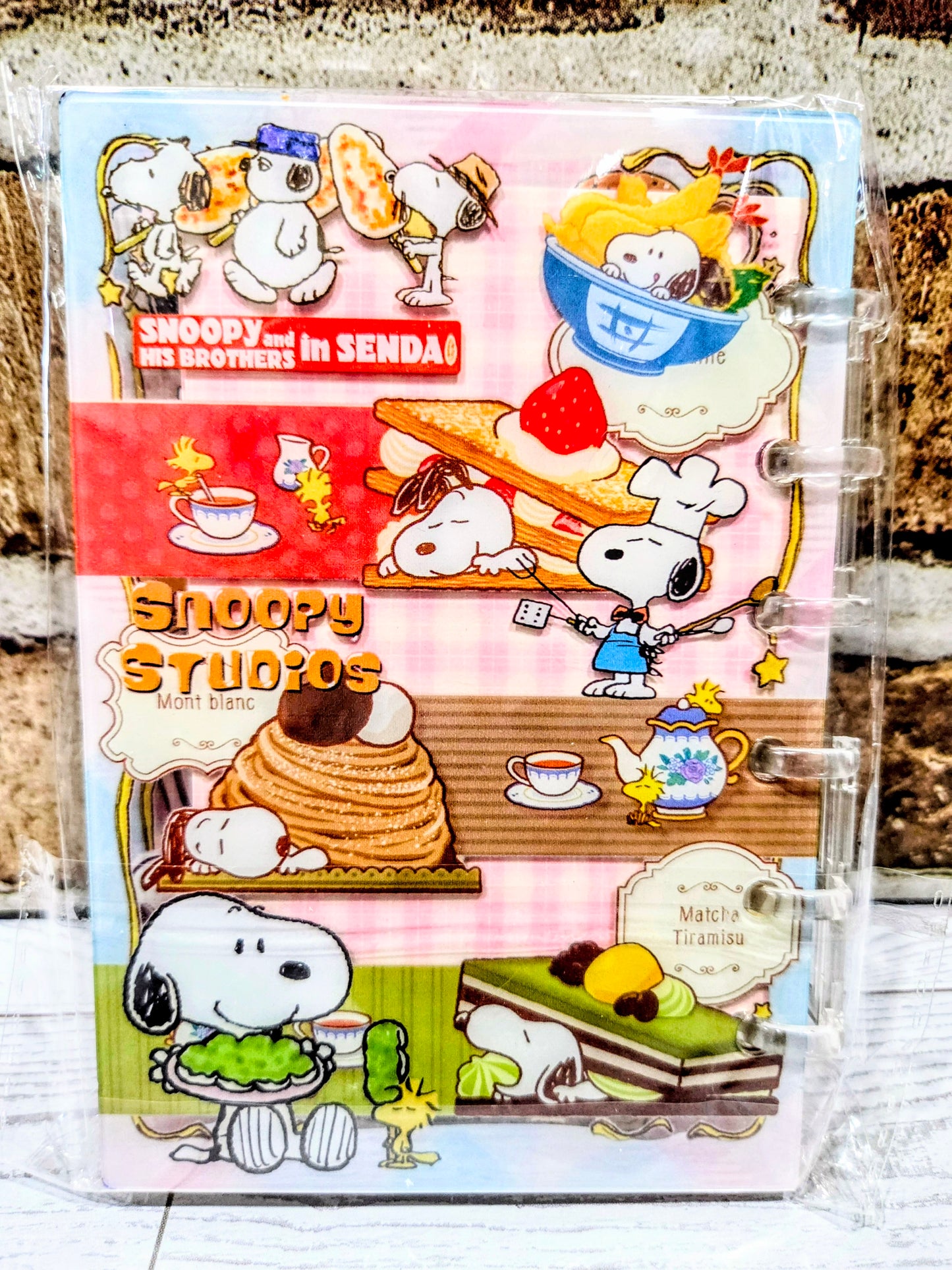 Pink acrylic shaker notebook with Snoopy Studios dessert and teacup themed illustration