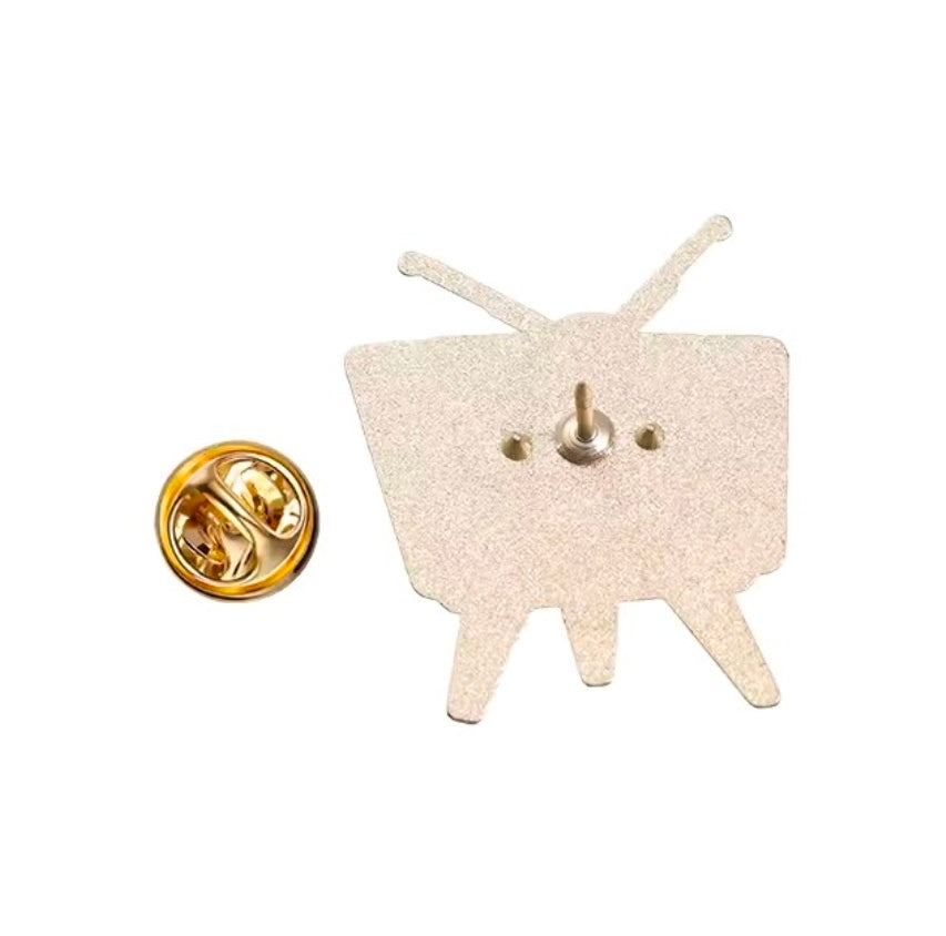 Enamel pin backing with gold tone circular clasp and beige back plate, two prongs
