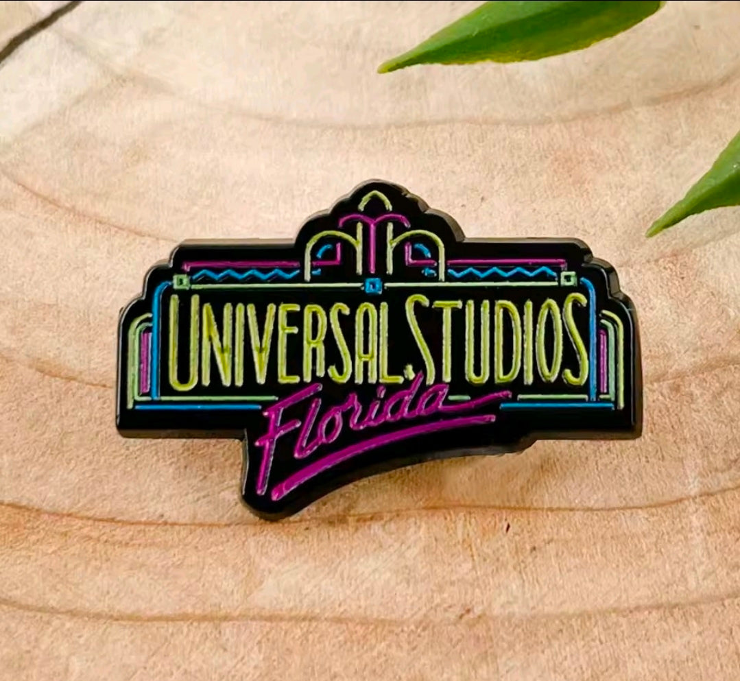 Universal Studios Florida enamel lapel pin on light wood surface