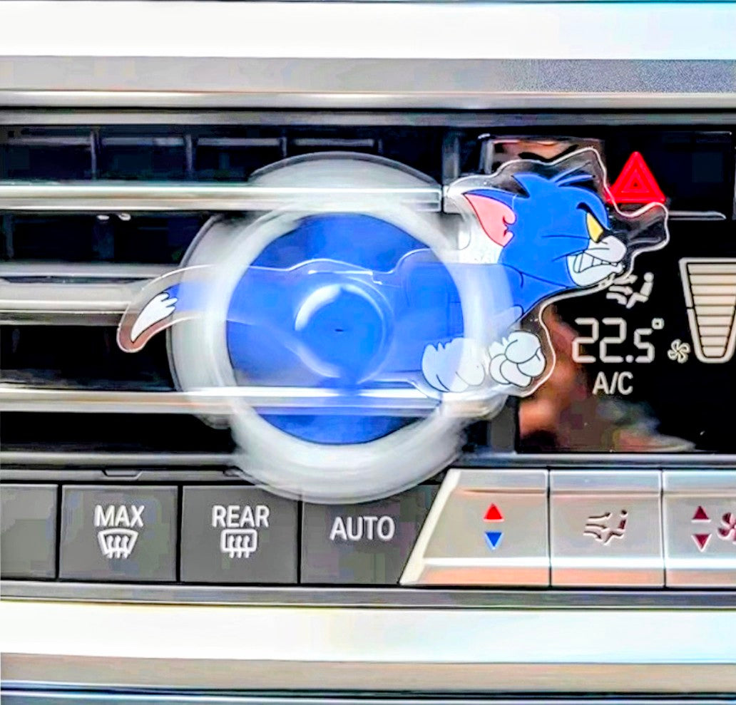 Blue cartoon cat acrylic air-vent spinner clip shown on car dashboard vent.