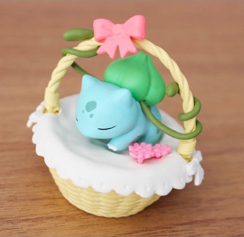 Vileplume nap basket figure with pale green body and pink flower on white blanket.