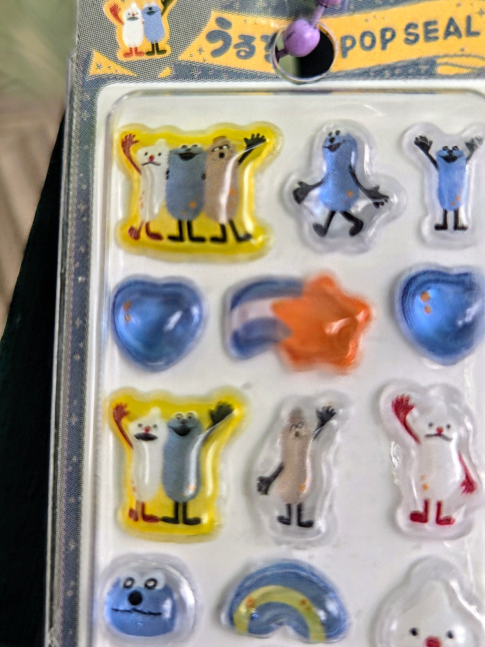 Sticker keychain blister showing blue, orange, and white animal icons in compartments
