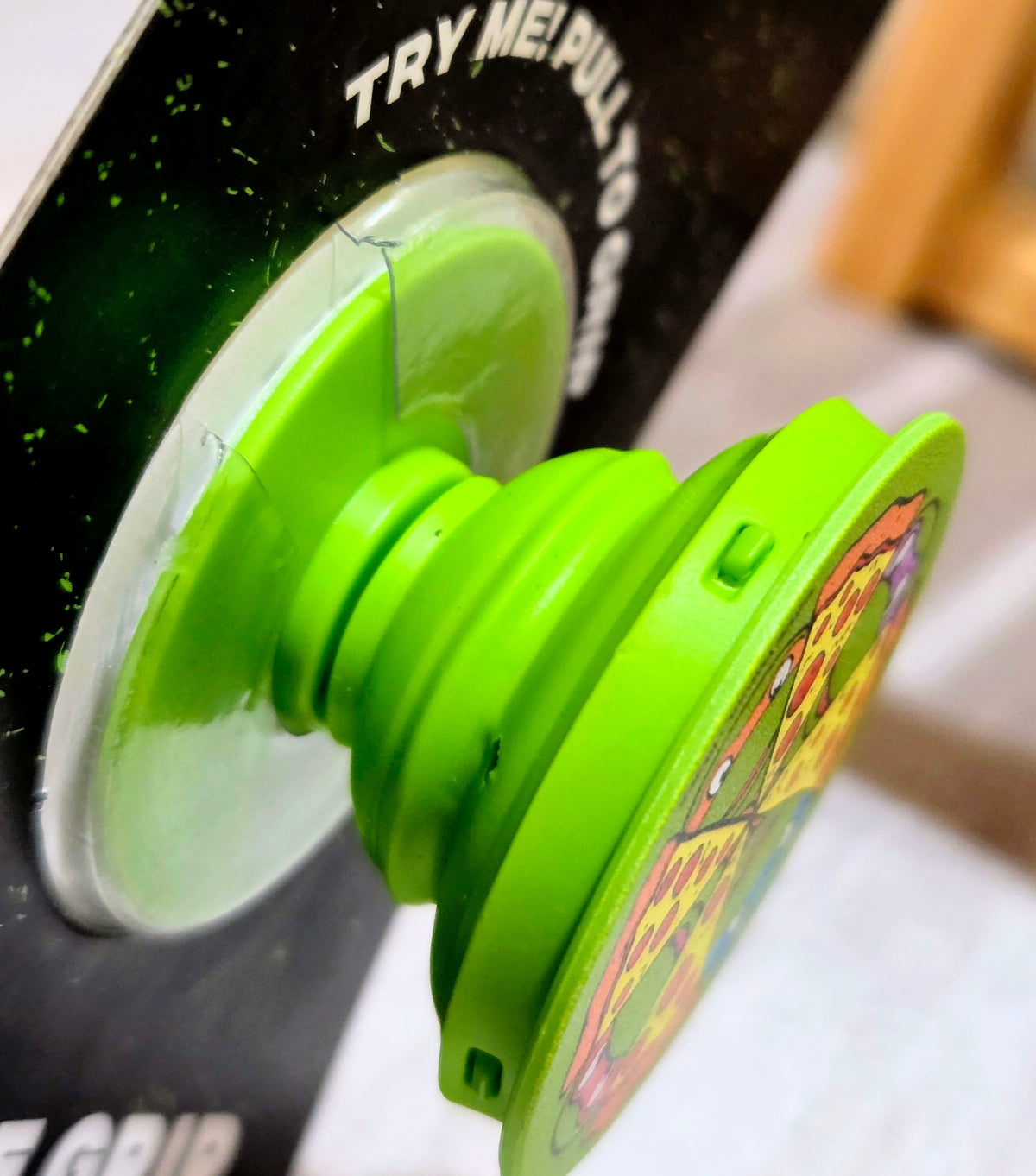 Green TMNT phone grip accessory with circular base and top graphic