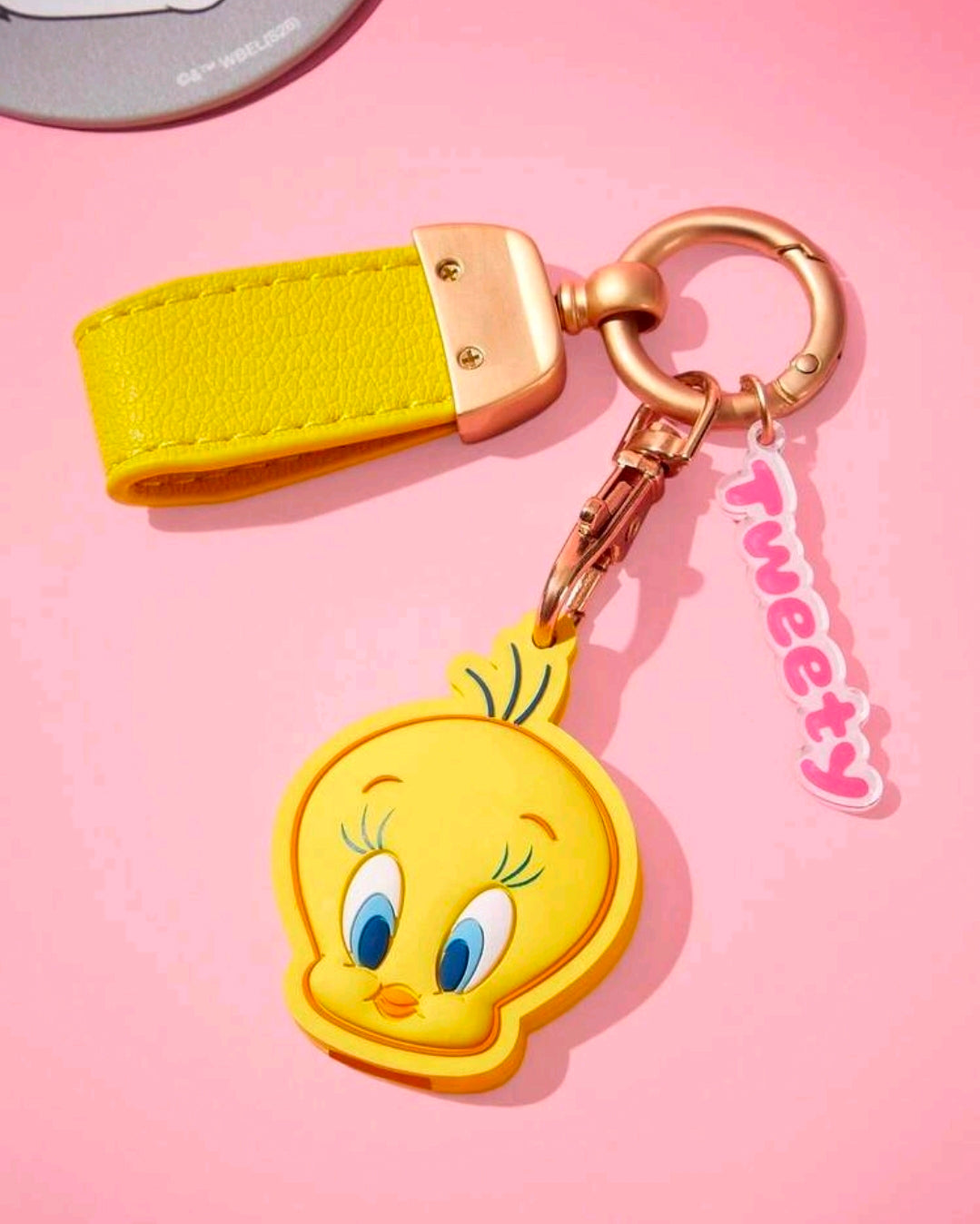 Yellow leather keychain strap with gold hardware and Tweety Bird face charm