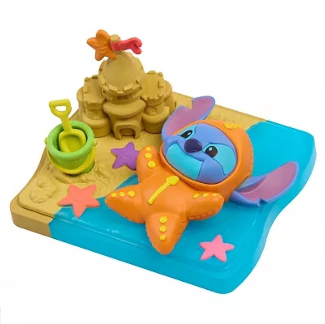 Stitch blind box figure in orange starfish suit on blue tray with green bucket and stars