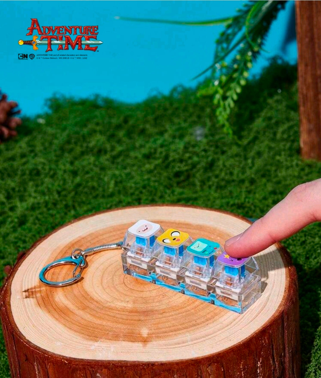 Clear clicker keychain with stacked character blocks; hand holds the keyring
