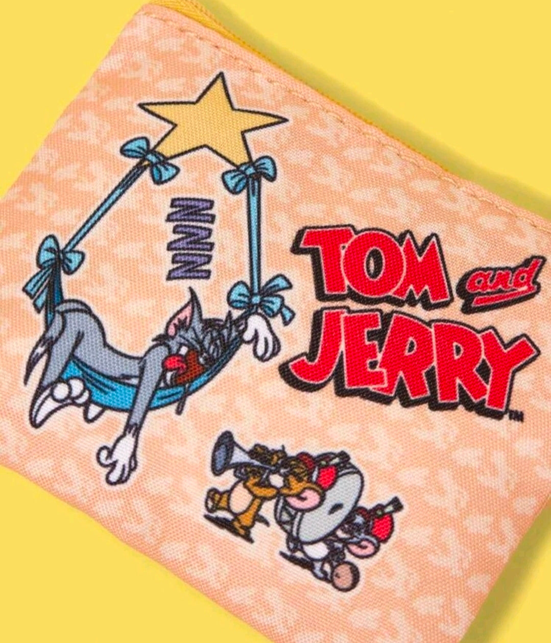Tom and Jerry zipper pouch close-up with star, characters, and bold text