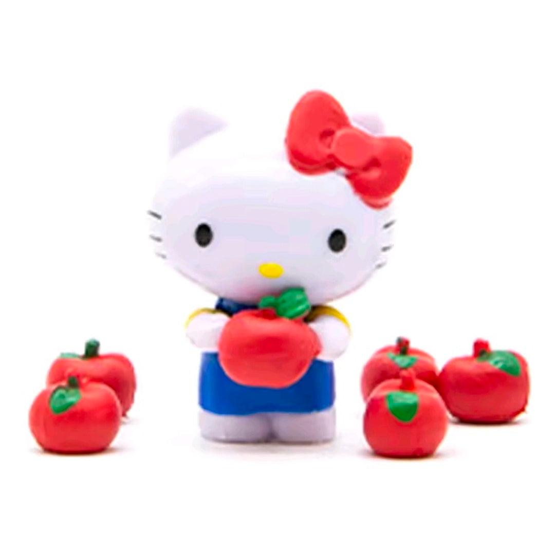 Hello Kitty mini figure holding a red apple and green accents, with apple pieces