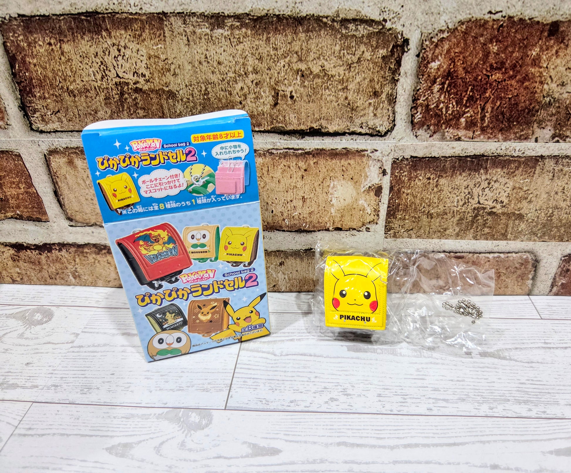 Toy set box with small Pikachu mini bag and a metal chain accessory on display