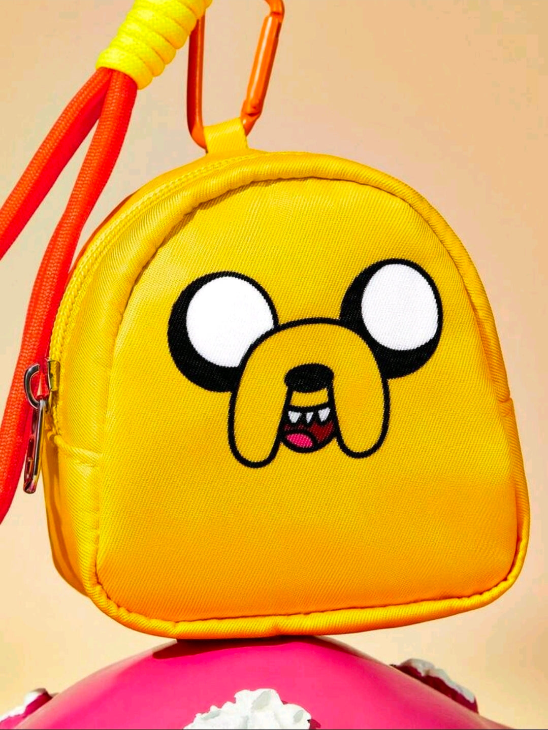 Yellow mini zipper pouch front with Jake dog face, orange wrist strap