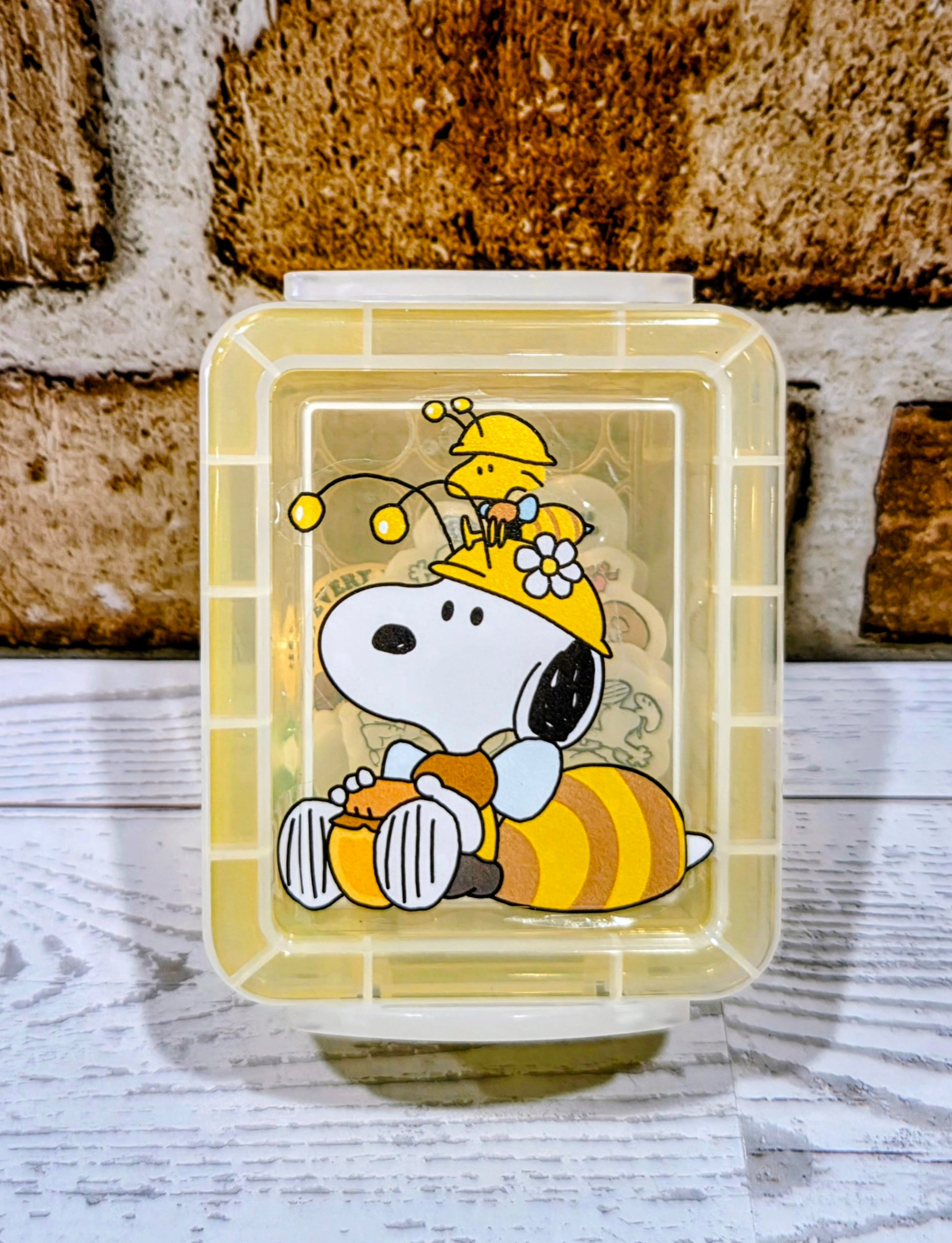Yellow desktop organizer box with clear lid and Snoopy character print on the front