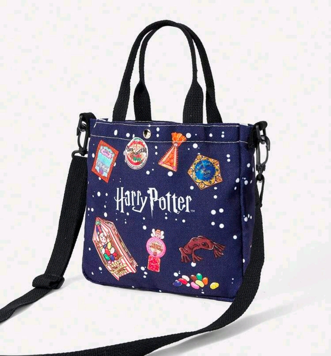 Navy canvas tote bag with double handles, black crossbody strap, and colorful charm print