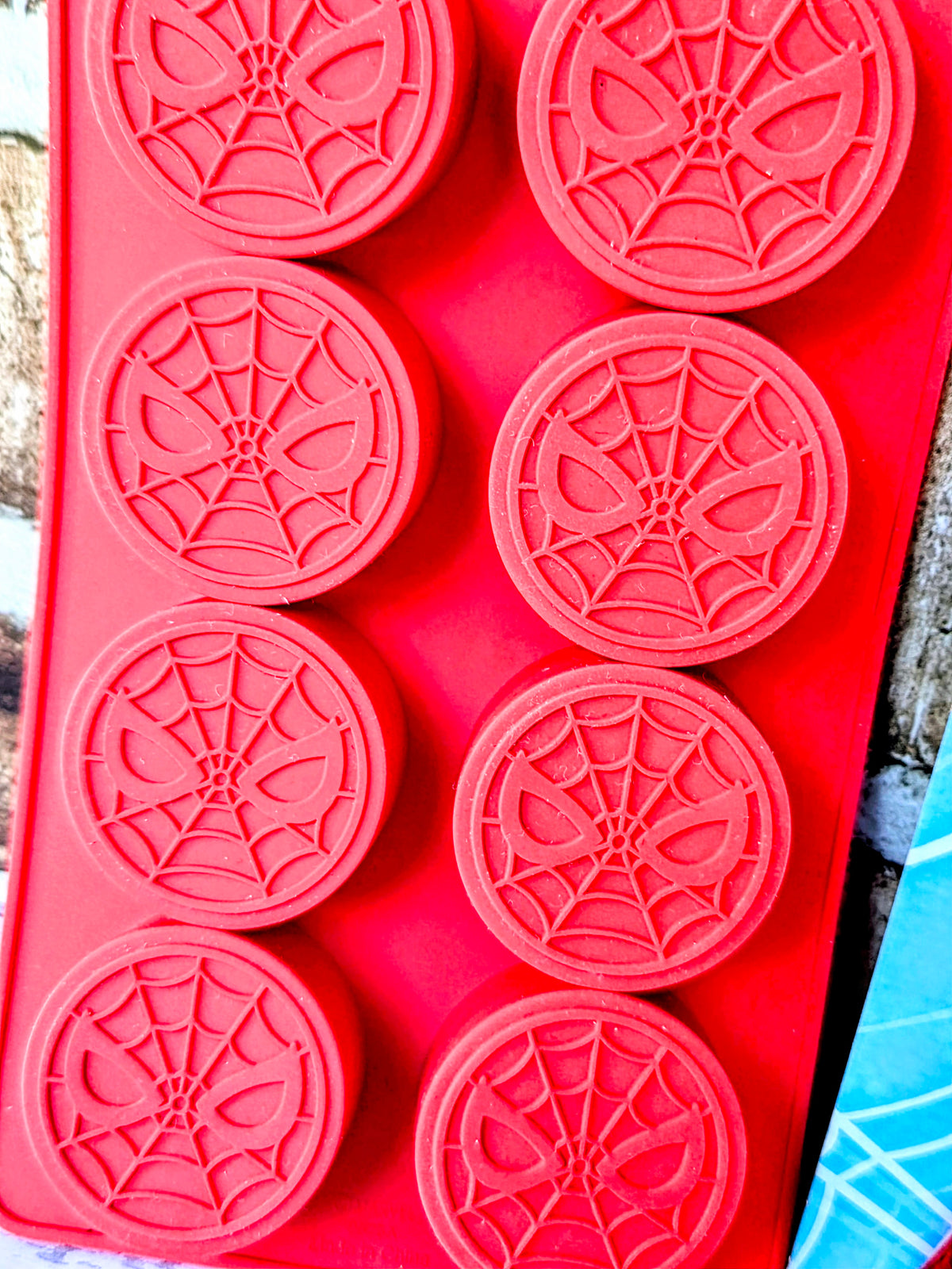 Red silicone Spider-Man ice cube mold tray with 8 round web-pattern compartments