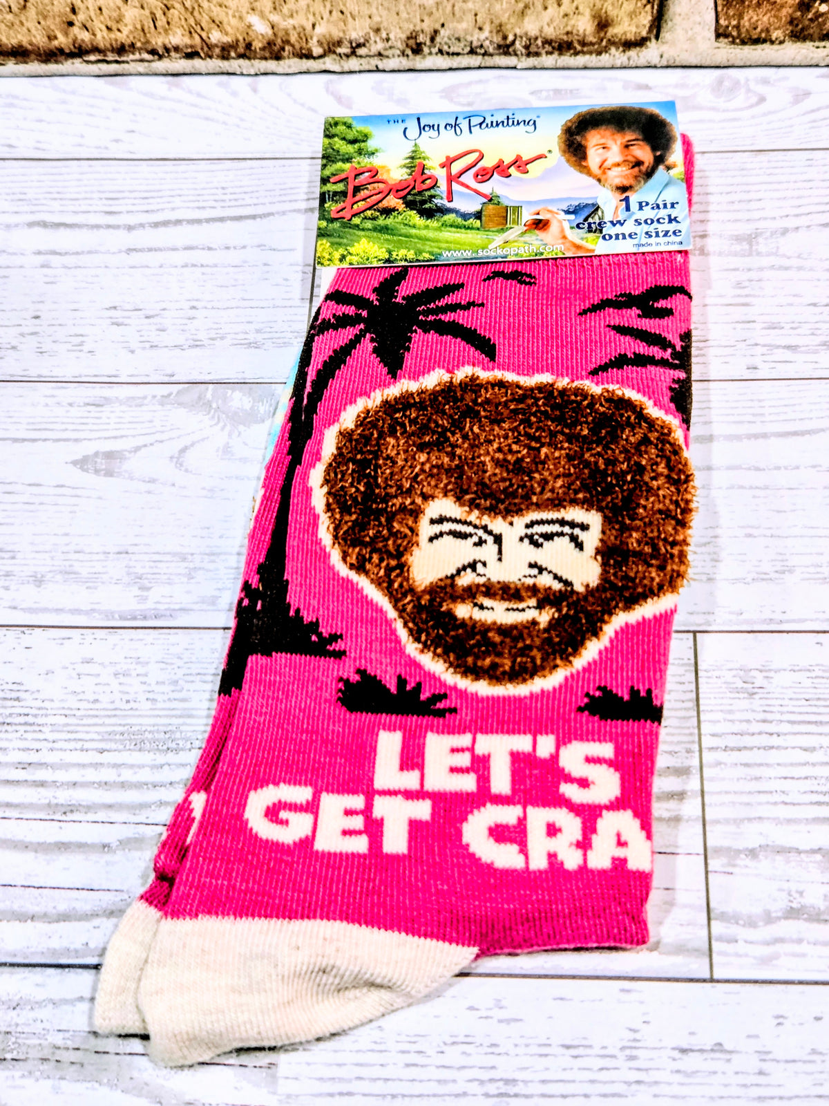 Pink crew sock with brown afro face graphic and 'LET'S GET CRA' text