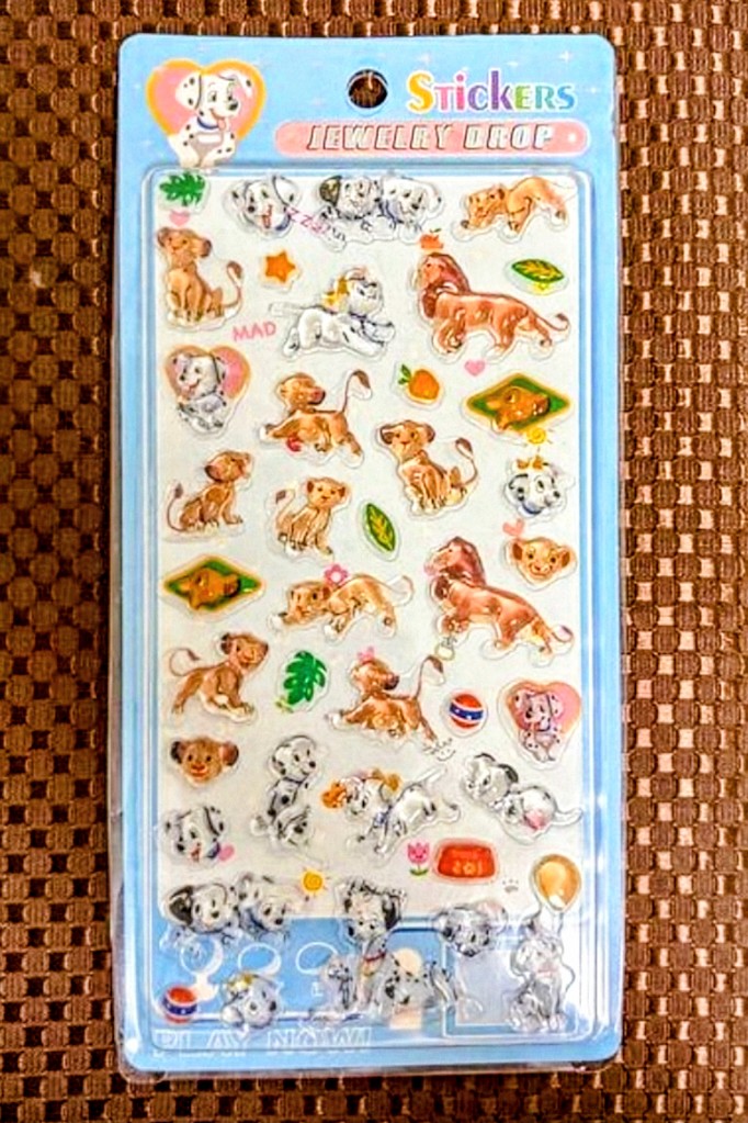 Collectible sticker sheet featuring dalmatian dogs, orange lions, and colorful accessories