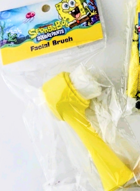 Yellow facial brush with SpongeBob SquarePants in clear blister packaging