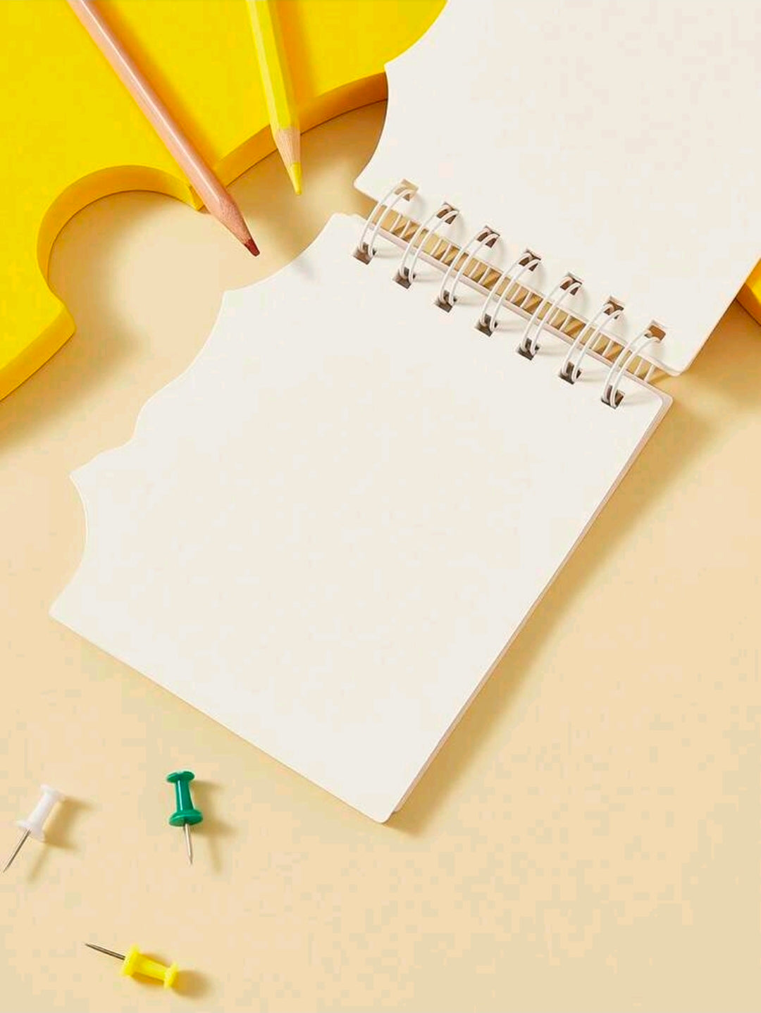 Mini spiral notepad open to blank pages with spiral binding