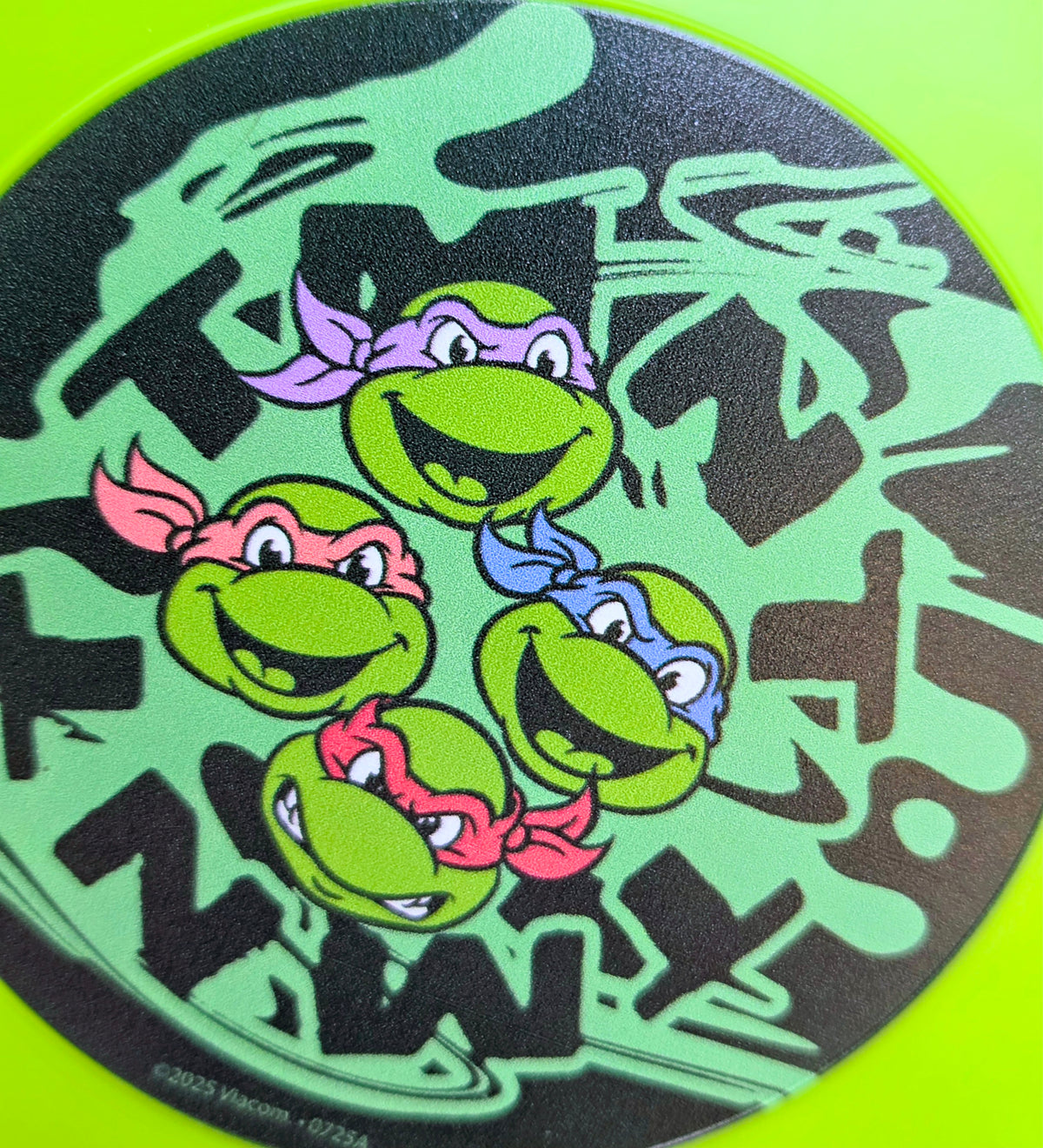 Neon green frisbee top with TMNT character graphic in graffiti style