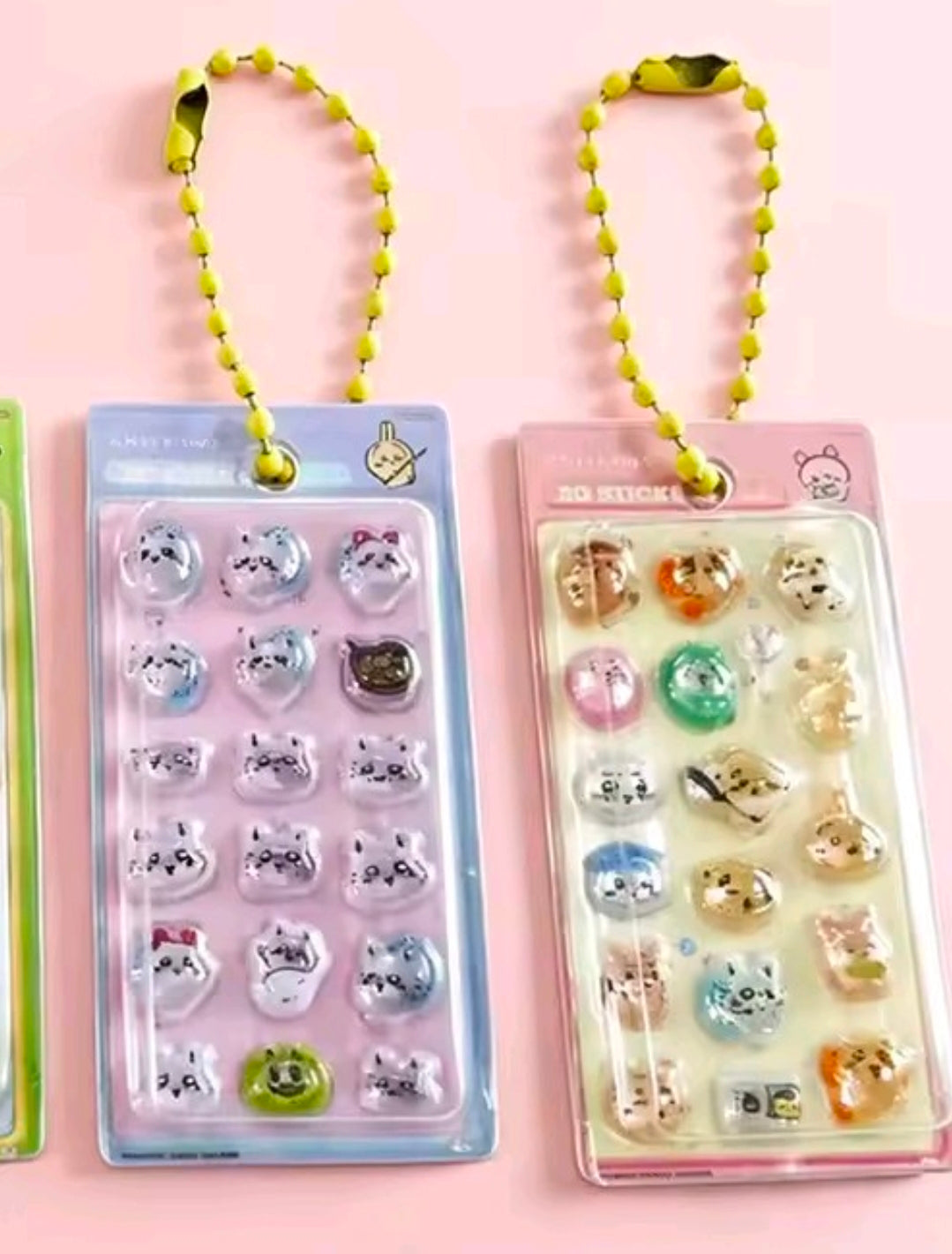 Two Chiikawa sticker keychains: purple and beige blister packs with neon-yellow bead straps