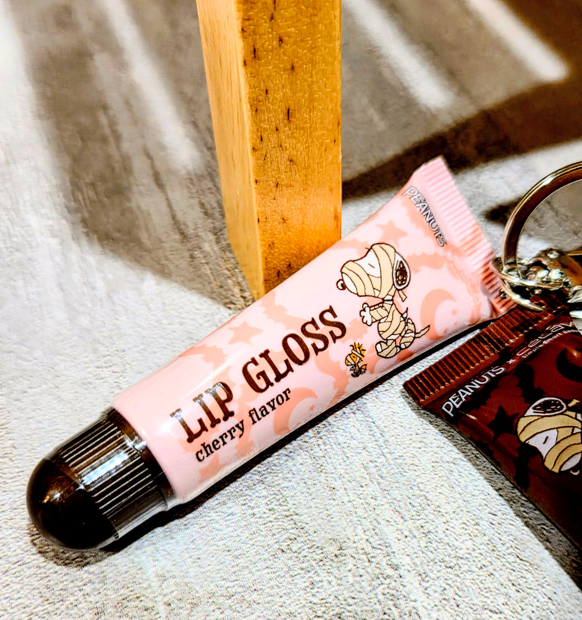 Cherry-scent lip gloss tube with keychain attached and pink wrapper