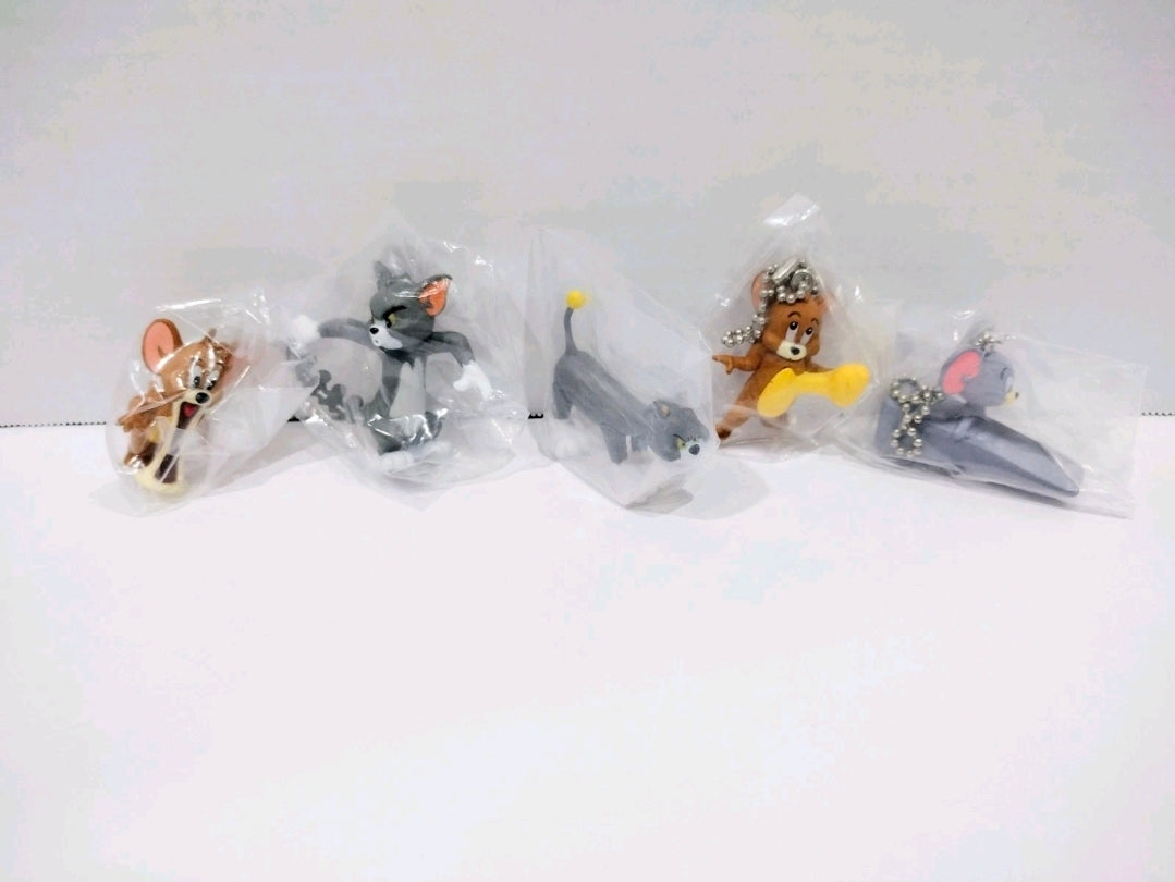Five Tom and Jerry keychains sealed in clear plastic with silver chain loops