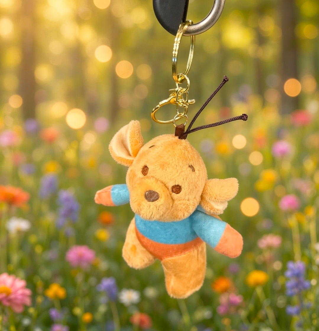 Roo mini plush keychain hanging from gold key ring, blue shirt and orange smiling face