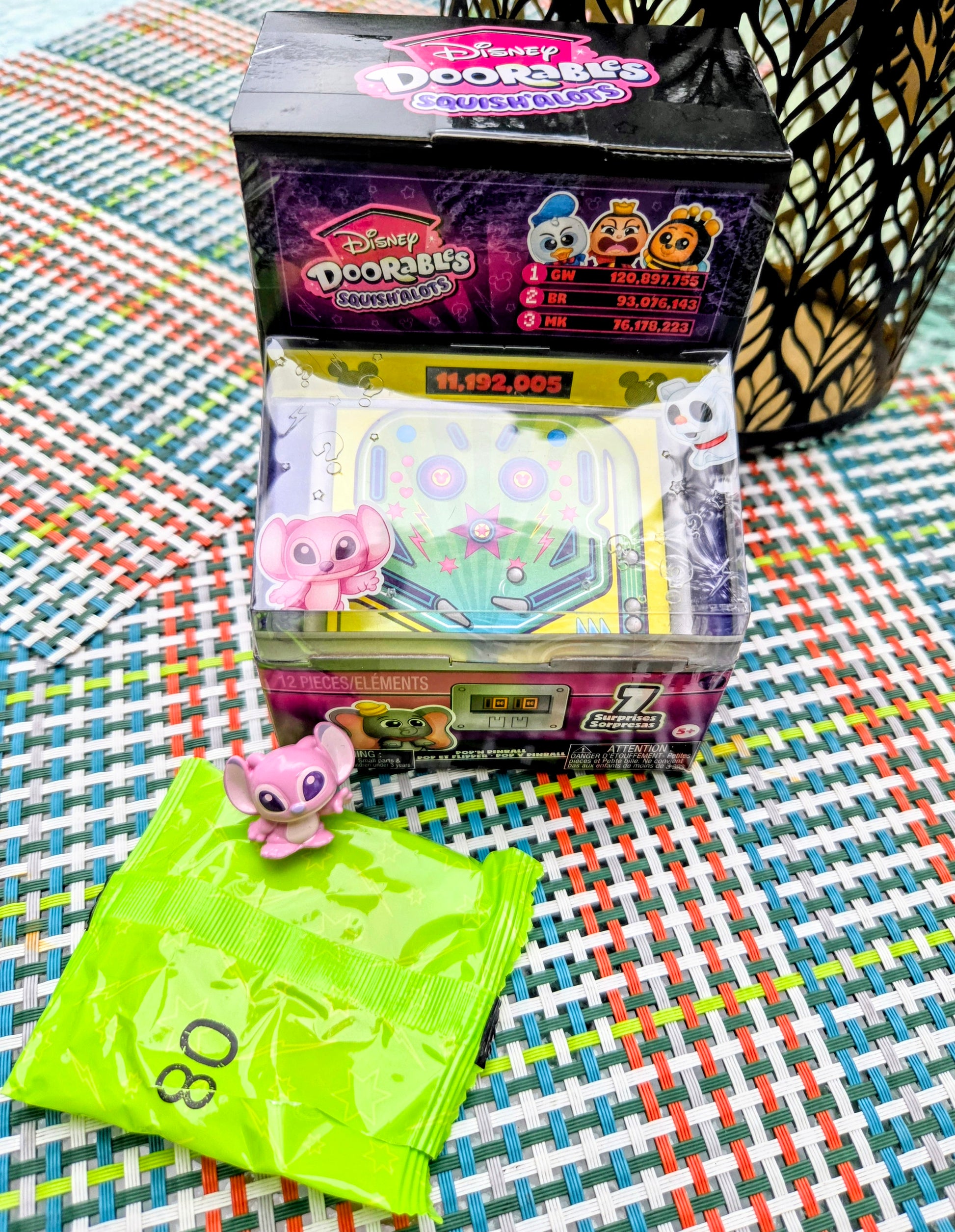 Pink Squish'alots figure beside neon green surprise bag with Pop N' Pinball box