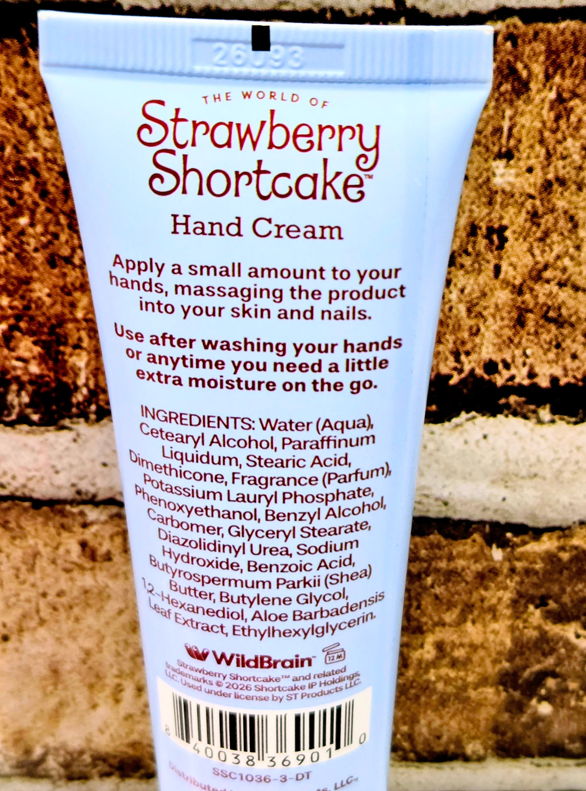 Strawberry Shortcake hand cream tube with blue cap, ingredients list, and barcode
