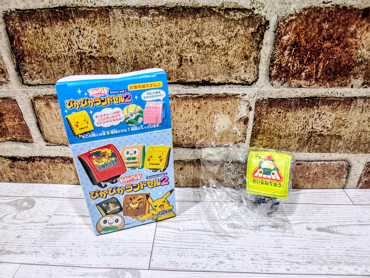 Toy blind box display with small blue and yellow mini school bag figures