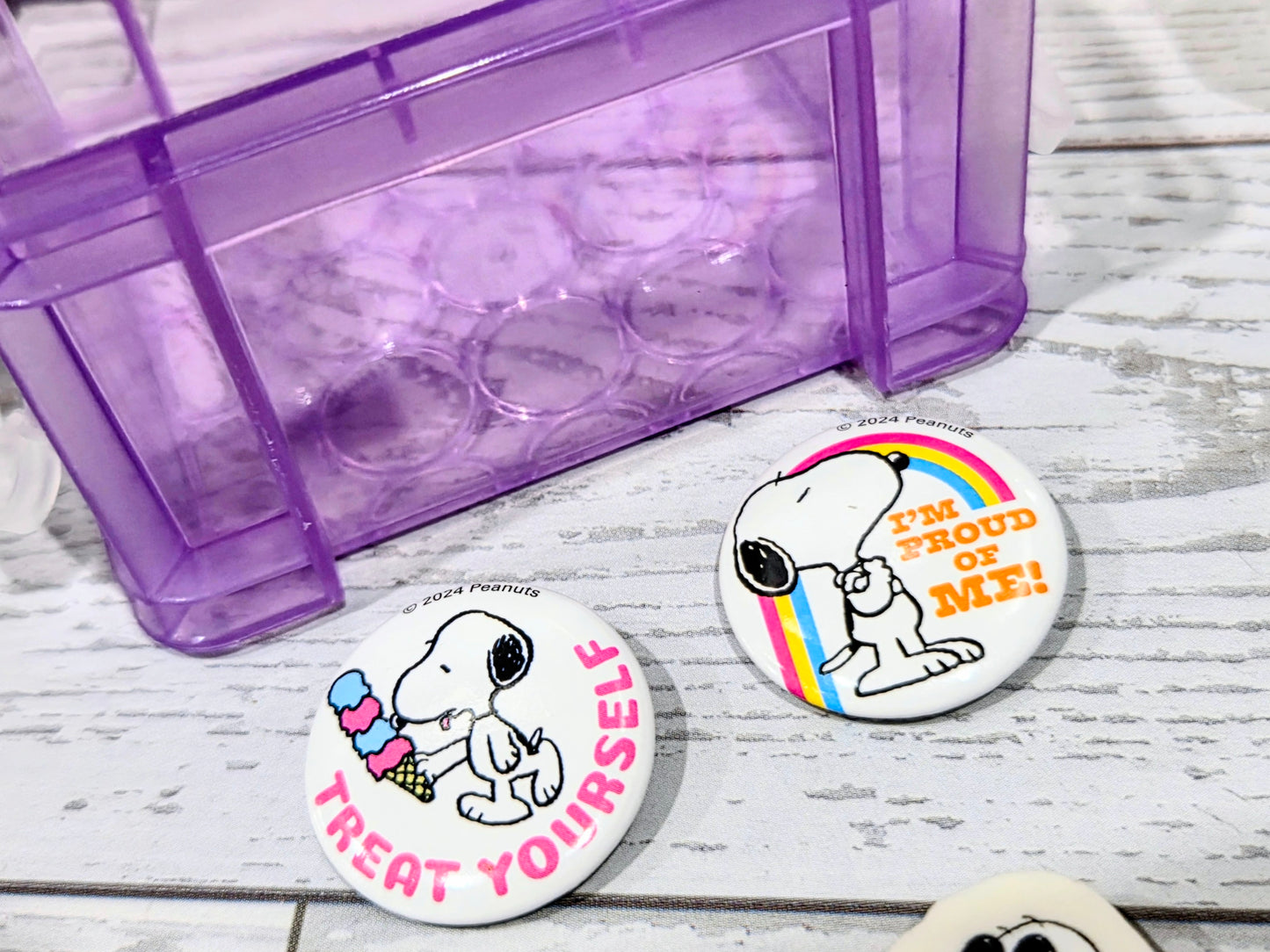 Purple desktop organizer box with round Snoopy erasers and printed slogans