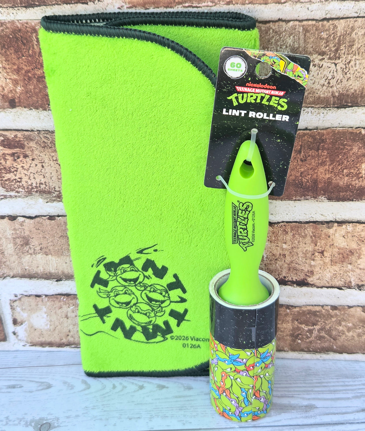 Neon green fleece pet gift pouch with zipper, plus TMNT lint roller and card