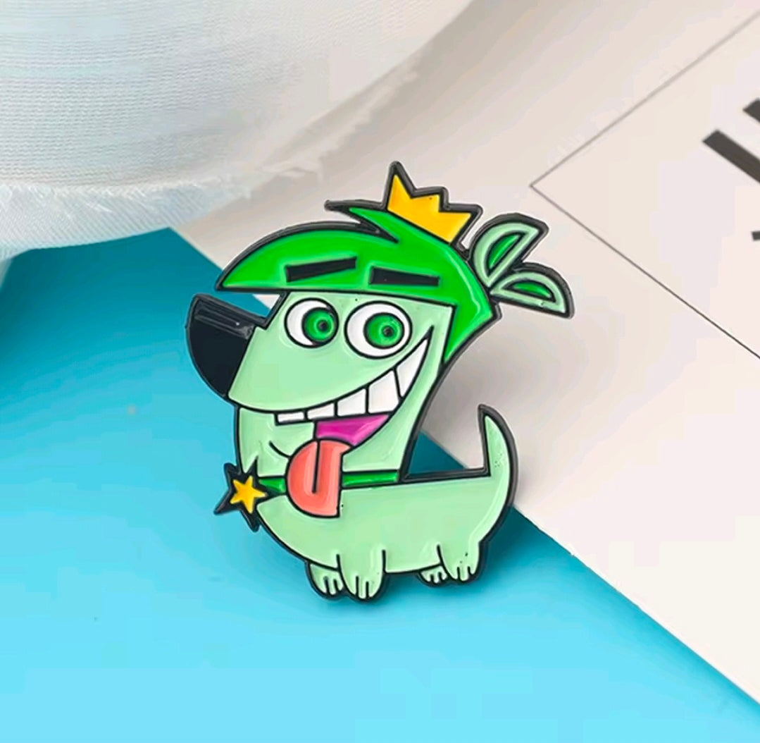 Close-up of a green enamel character pin with a yellow star and red tongue