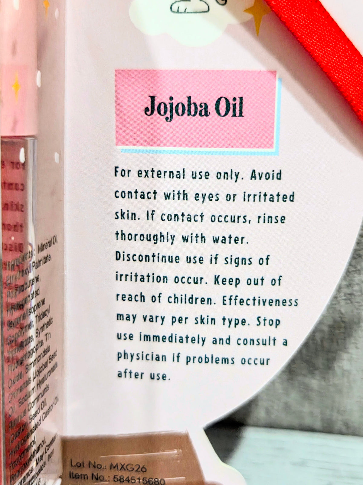 Tinted lip oil box back label with Jojoba Oil directions and warning text